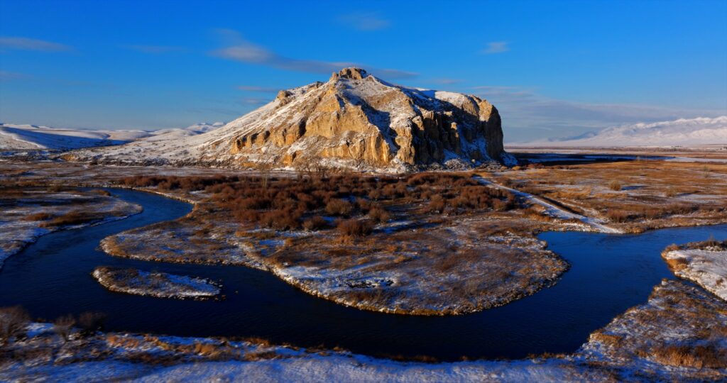 An aerial view of Beaverhead Rock near Dillon, Montana, overlooking the snowy bends of the Beaverhead River as it winds through frost-covered ranchland below. Photo by Mike Dreesman, Tempest Technologies LLC.