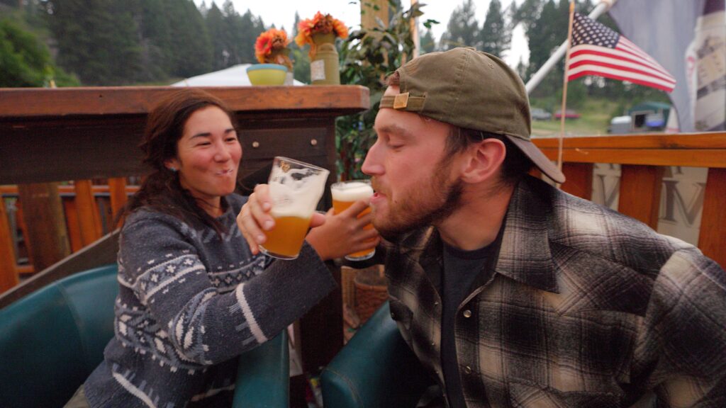 Two people cross arms and drink locally brewed beer at Philipsburg Brewing's The Springs location. 