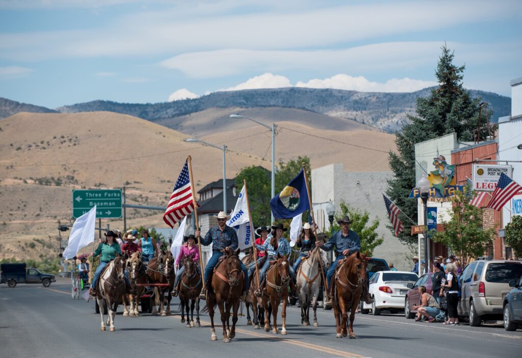 Horseback riders carry American and Montana state flags down Main Street during the Broadwater County Fair parade in Townsend, Montana, with the Big Belt Mountains in the background. Photo by Donnie Sexton, Montana Department of Tourism.