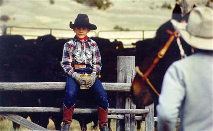 Mulvey Gulch Ranch: kid on corral fence